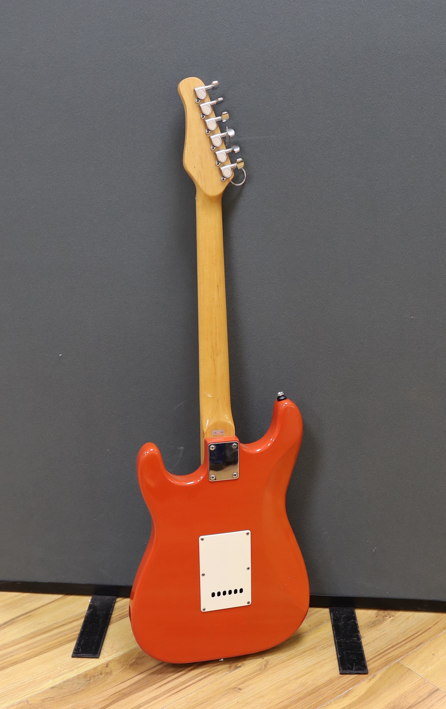 A JCX Stargazer electric guitar with maple neck and orange lacquered body